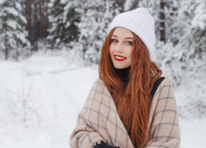Frau mit langen roten Haaren im Schnee
