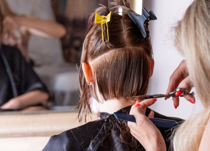 Frau, die sich die Haare kurz schneiden lässt