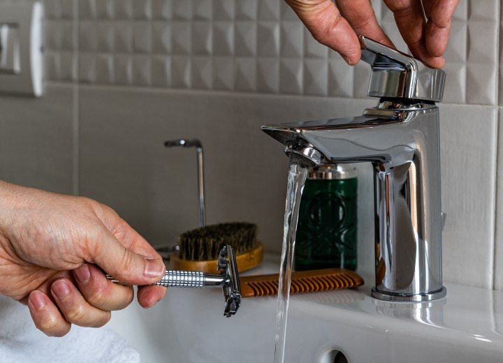 Ein Rasierer mit Wasser abspülen