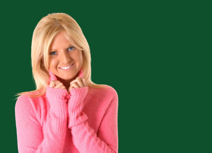 Blonde Frau die einen rosa Rollkragenpullover trägt