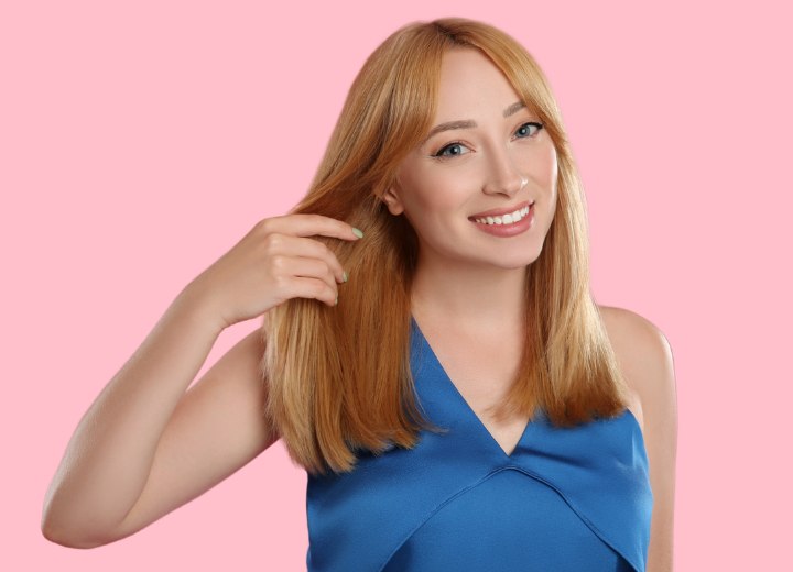 Blondes Mädchen, das seine Haare auf Haarschäden überprüft