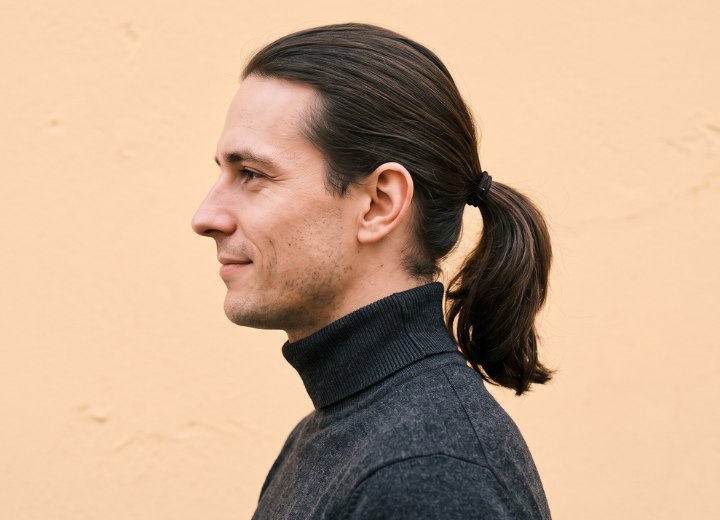 Mann, der seine Haare als Pferdeschwanz tr&auml;gt
