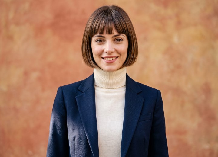 Frau mit einem cremefarbenen Rollkragenpullover und einem dunkelblauen Blazer